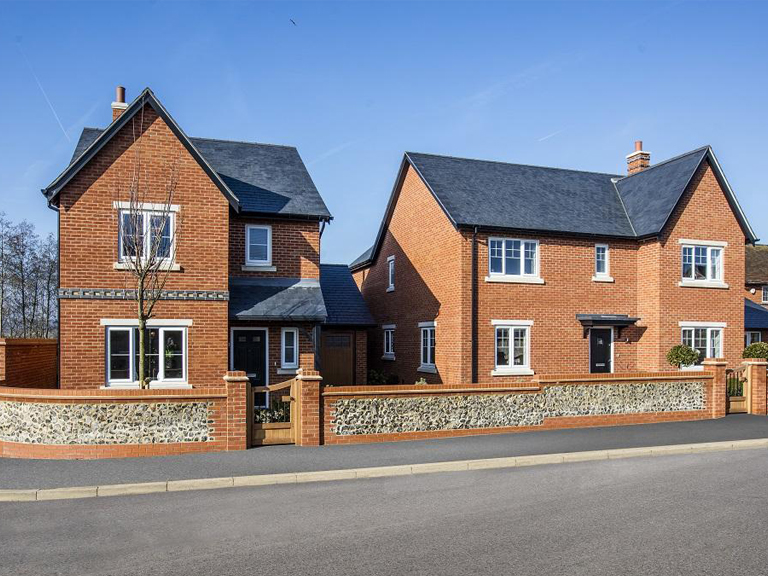 An image of new build houses featuring windows and doors fabricated and installed by Unique Window Systems.